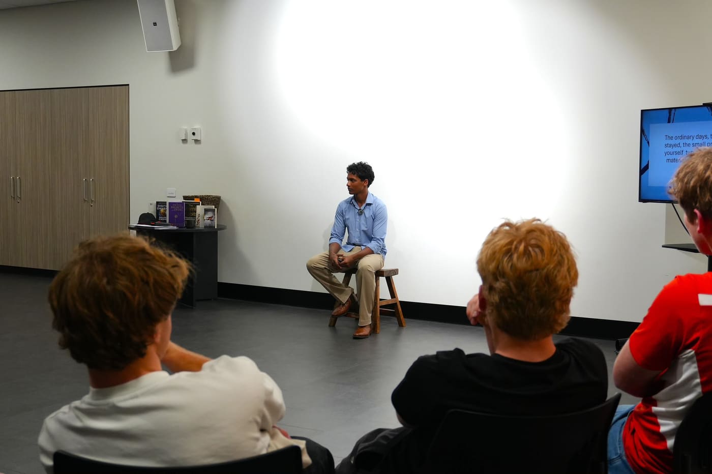 Prem, the founder, sitting on a stool and speaking to the group