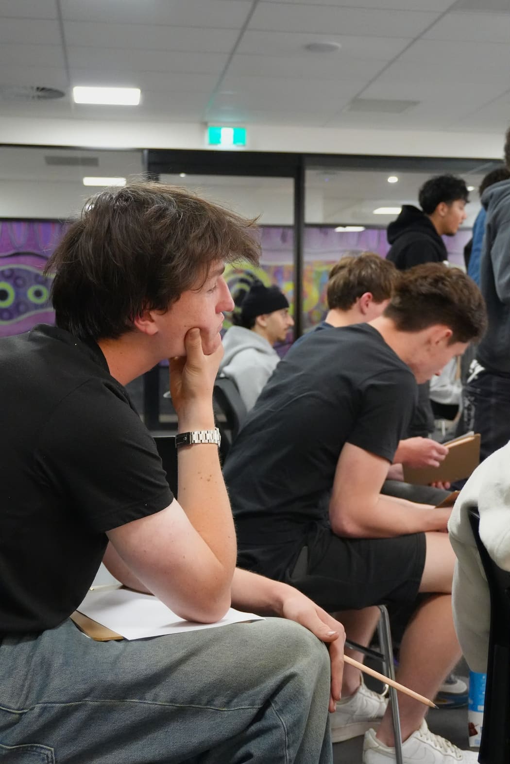 A young person resting their chin on their hand, listening closely