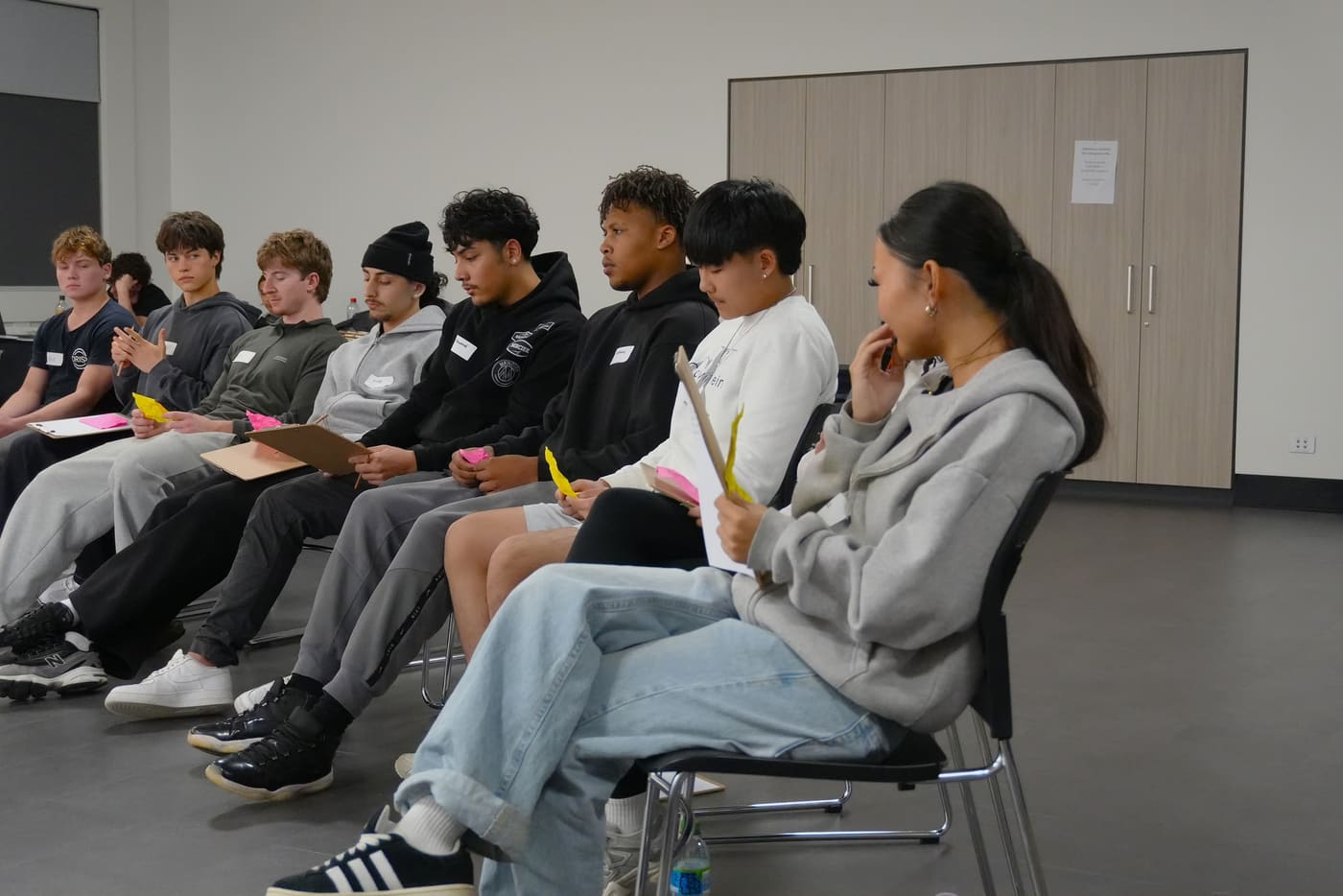 A row of young people seated and listening during a session