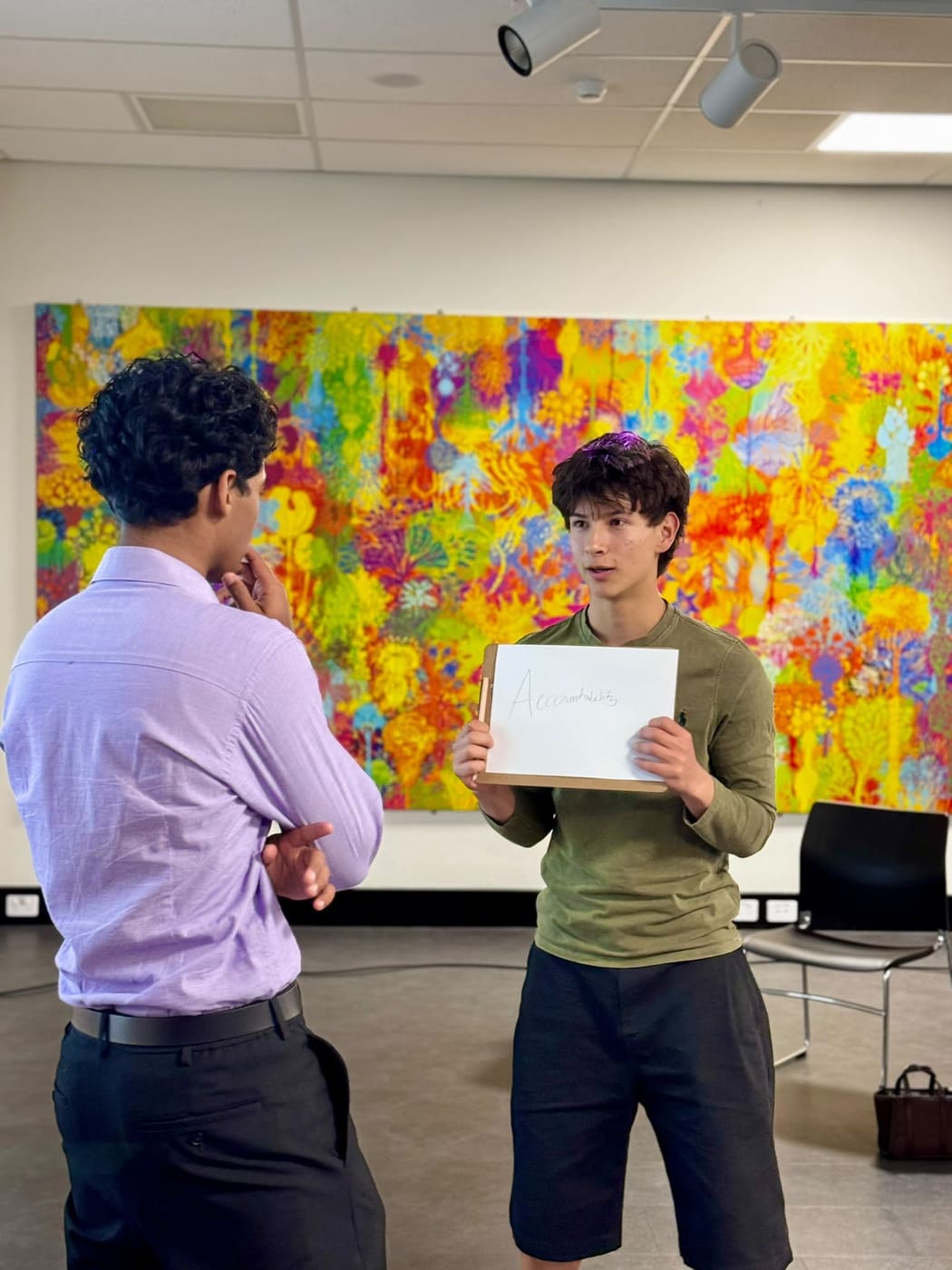 A participant holding a card reading Accountability while talking with a facilitator