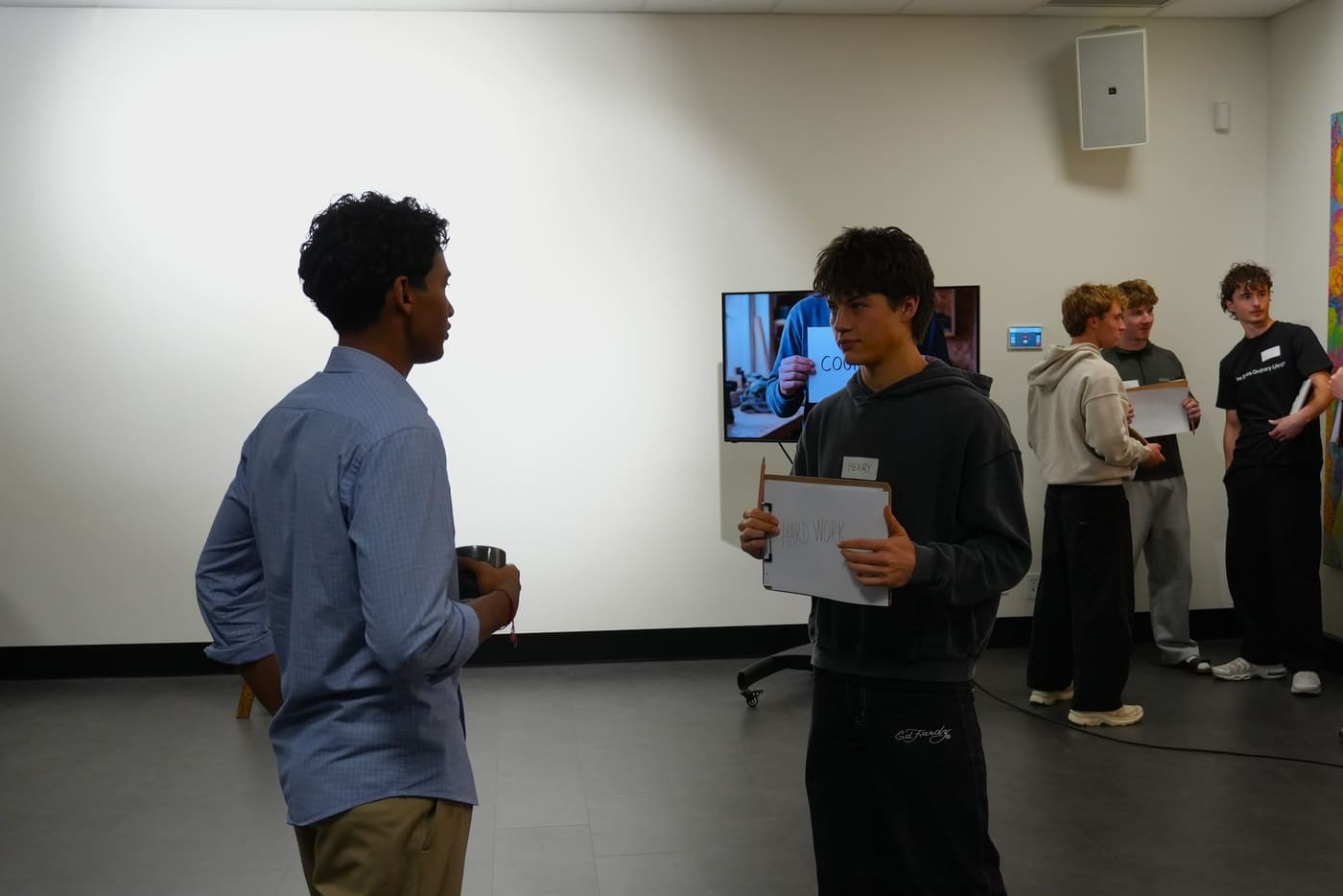 A participant holding a card reading Hard Work during a values exercise